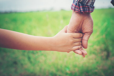 Father and daughter holding hands.